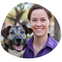 Keely Grant – Dog Groomer Chicago A photo of Keely, brown haired lady holding a dog and smiling